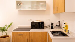 A kitchen with a microwave, a kettle, a sink, and a shelf with glassware. - Casa Verdi with Terrace, 1 Bedroom, Living Room (Tanger)