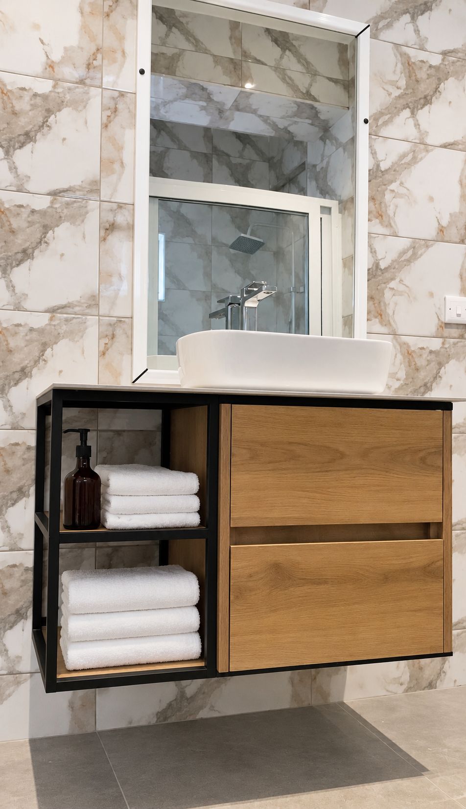 A bathroom with a marble wall, a glass shower enclosure, a white sink, and a wooden vanity with shelves.