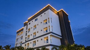 Ein mehrstöckiges Hotel mit modernem Design, das durch einen markanten, vertikalen Abschnitt auf der rechten Seite gekennzeichnet ist.