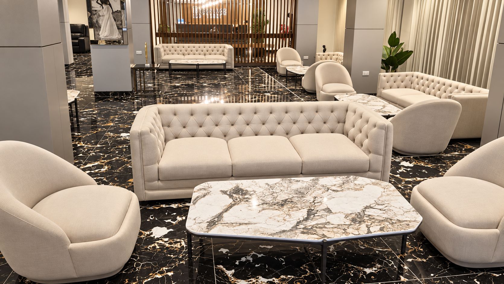 A modern interior with a tufted sofa, armchairs, and a marble coffee table.