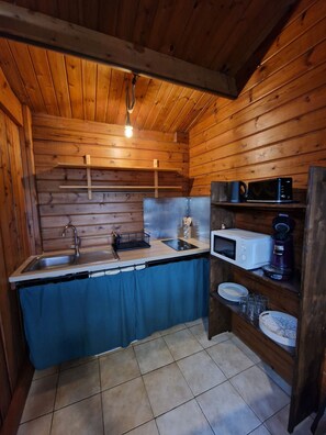 A compact kitchen with wooden walls, a sink, a microwave, and a coffee maker. - LA KAZ COSY — Private hot tub + pool, 2–3 people, Sainte-Anne (Sainte-Anne)