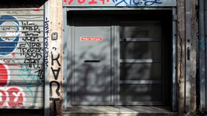 A building entrance with a metal door, graffiti, and a sign above. - Studio with a view of the Acropolis, close to the metro and tourist attractions (Athina)