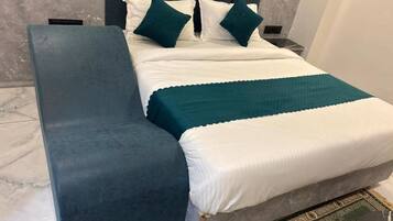 A bed with a headboard, a bench, and a patterned rug.