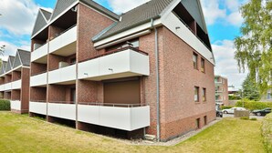 A multi-story residential building with brick exterior, balconies, and a flat roof. - Hansastrasse Building, Apartment 1 (Scharbeutz)