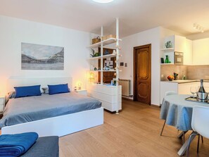 Um quarto moderno com cama, mesa de cabeceira e guarda-roupa embutido.