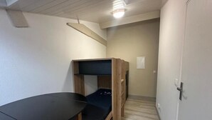 Una habitación con literas, un escritorio y una puerta.