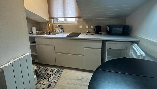 Una cocina compacta con ventana, microondas y lavavajillas.