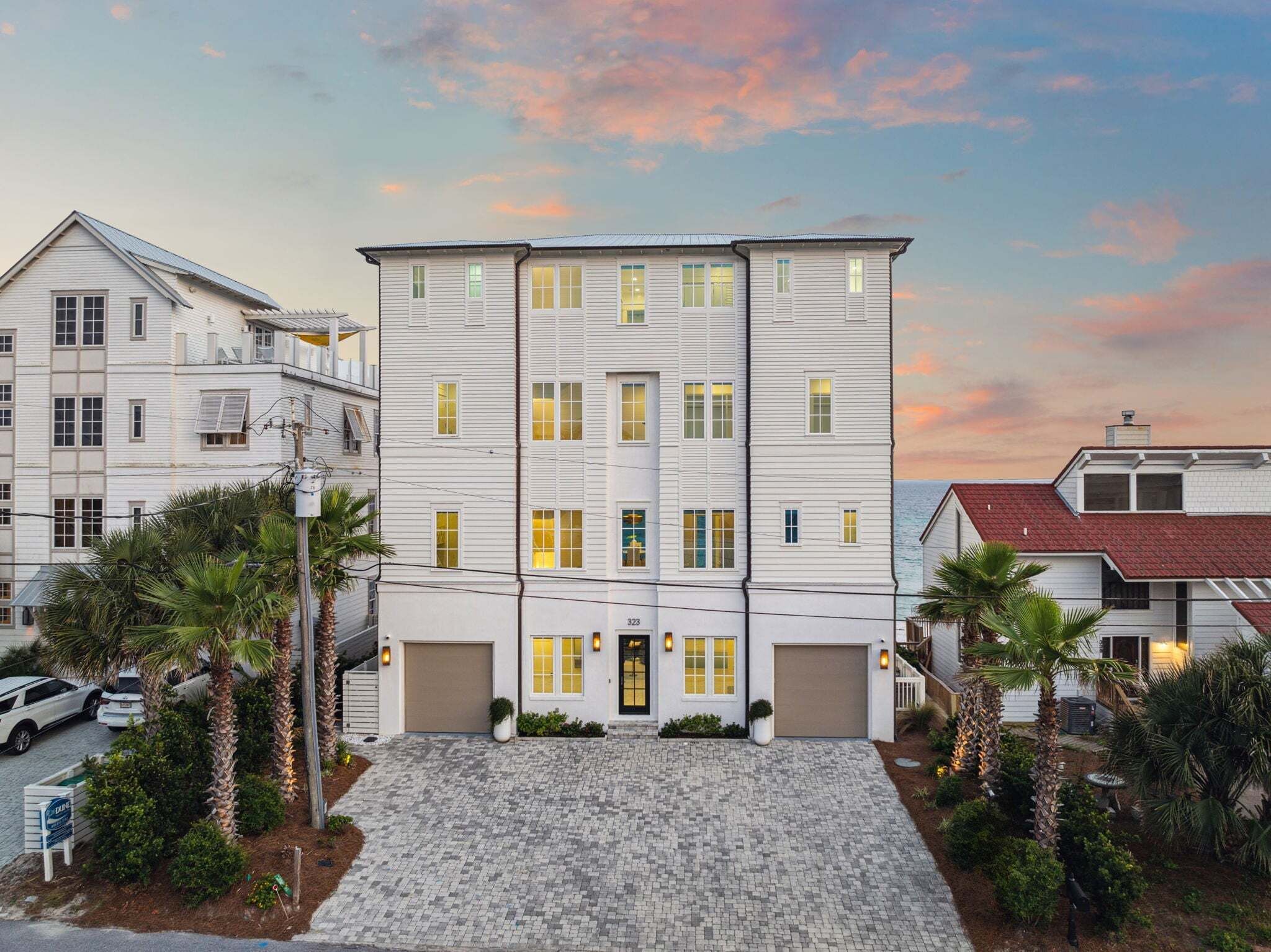 A multi-story building with a central entrance, garage doors, and a paved driveway.