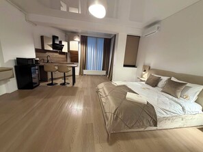 Ein Hotelzimmer mit Bett, Schreibtisch und einer Küchenzeile.