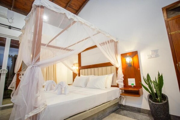Un dormitorio con cama con dosel, mesita de noche, lámpara de pared y planta en maceta.