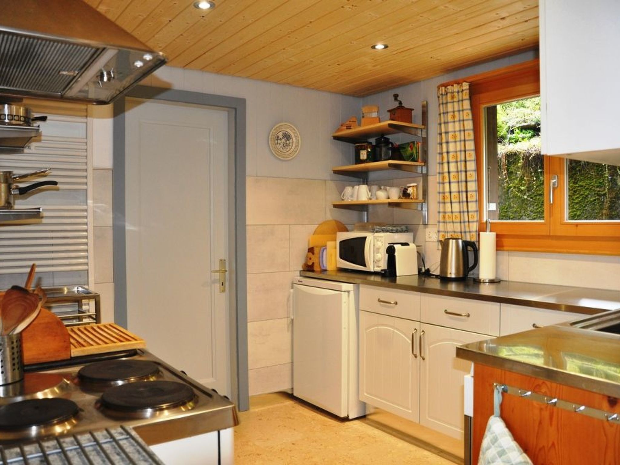 A compact kitchen with a stove, microwave, and refrigerator.