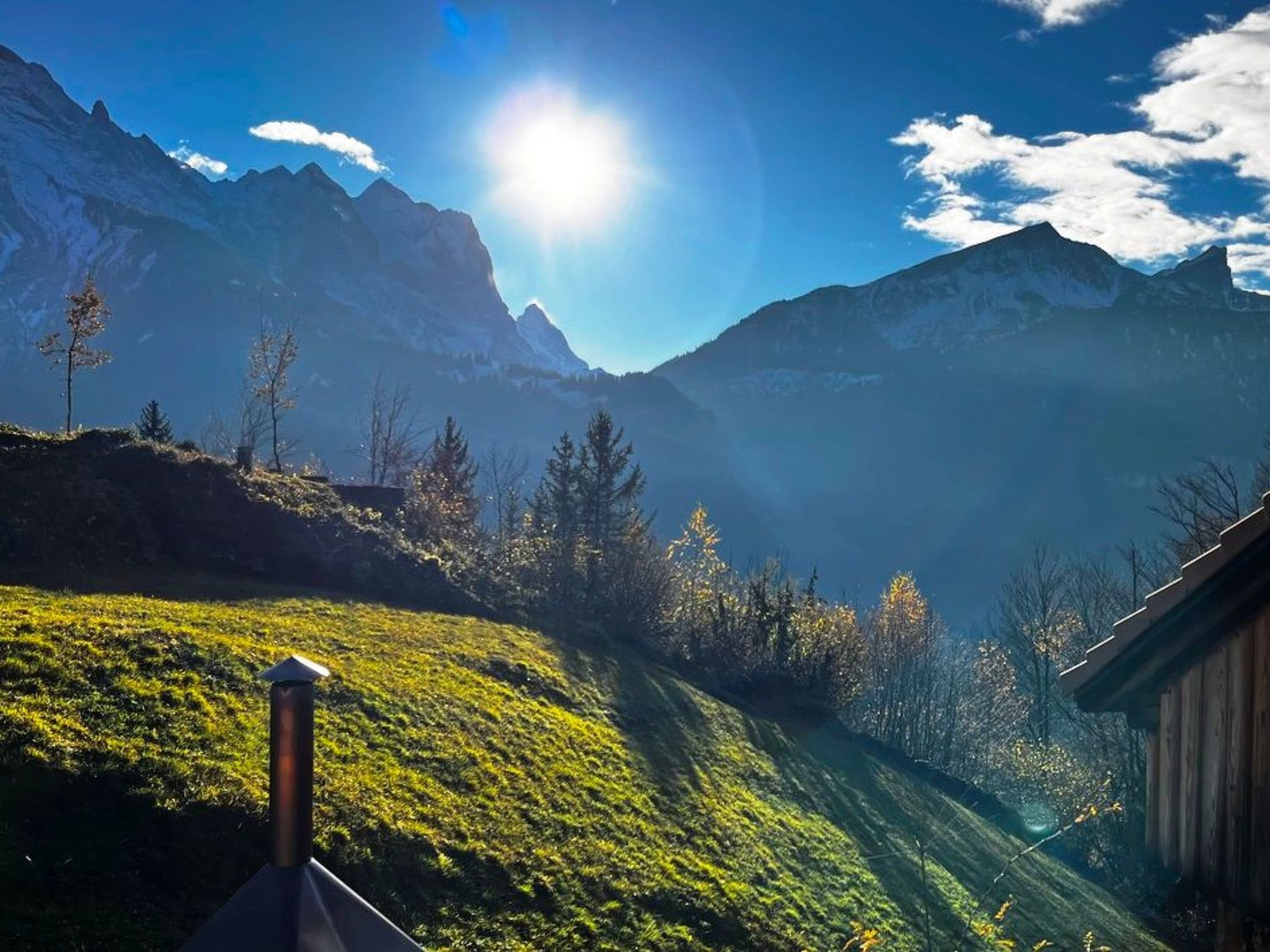 A mountainous landscape with a clear sky and sunlight.