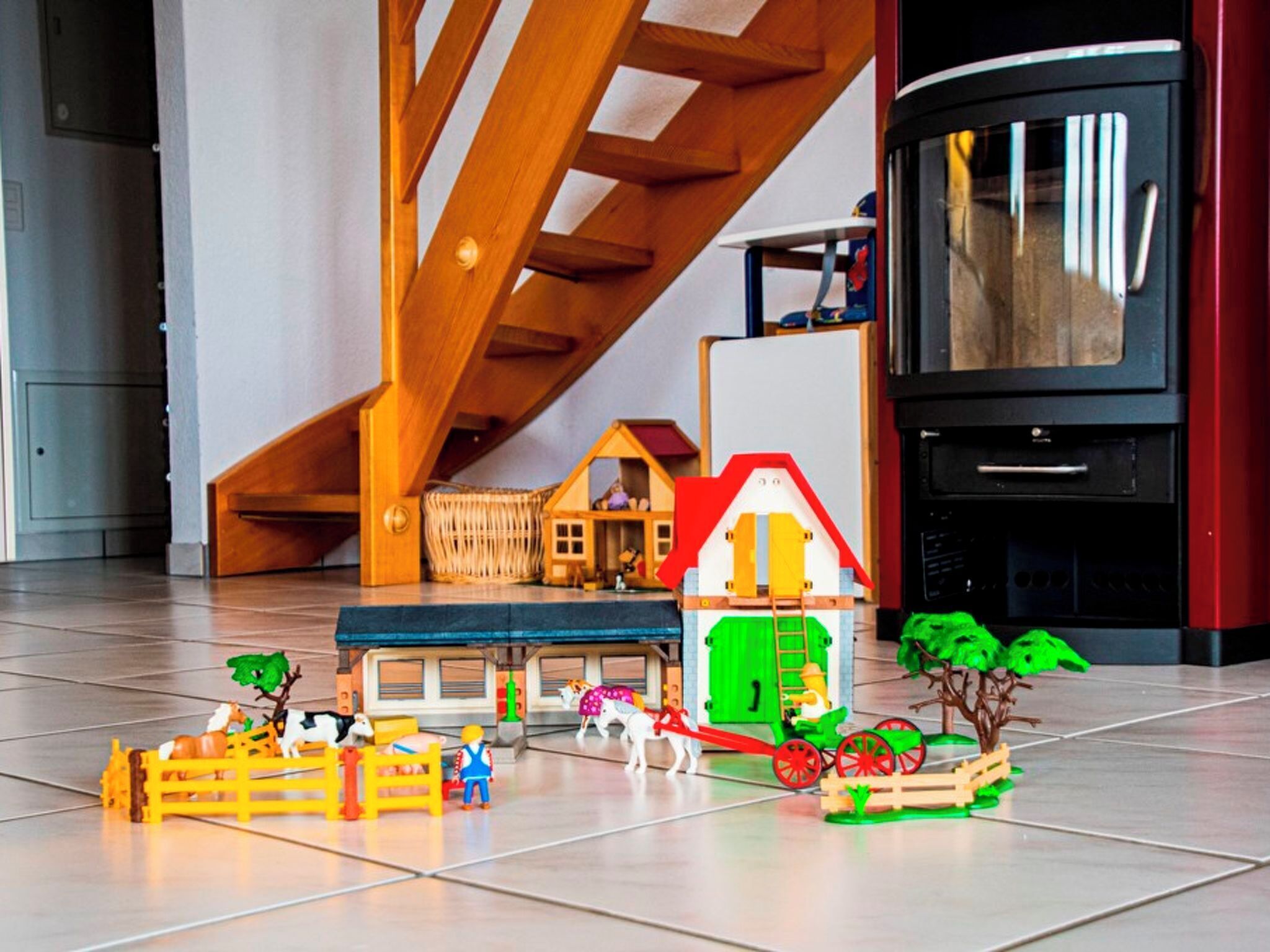 Un ensemble de trains miniatures comprenant des bâtiments, des arbres et des figurines, installé sur un sol carrelé.