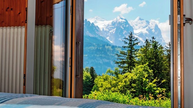 Une chambre dotée d’une grande fenêtre donnant sur les montagnes.