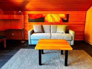 A cozy room with a sofa, a wooden coffee table, and a floor lamp.