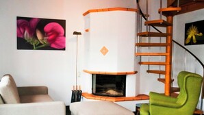 A modern living room with a fireplace, a green armchair, and a beige sofa. - HasliRent, Eiger, (Hasliberg Reuti), by Interhome (Hasliberg)