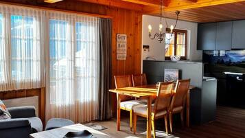 Un intérieur en bois comprenant un coin repas, un canapé et une cuisine.
