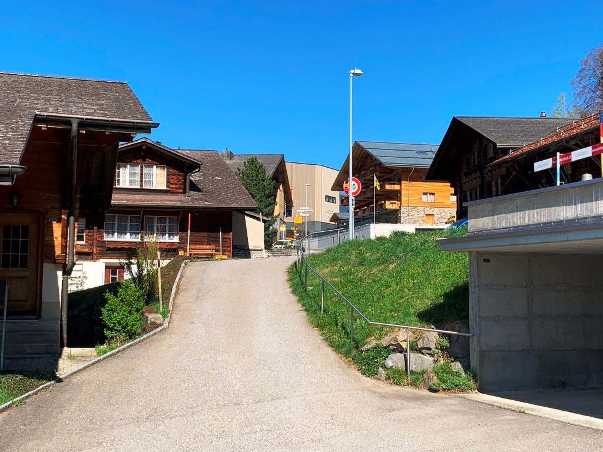 Une rue résidentielle bordée de maisons, un ciel dégagé et un panneau indiquant l’interdiction d’accès.
