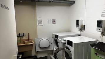 Une buanderie équipée d’un lave-linge, d’un sèche-linge et d’un évier.