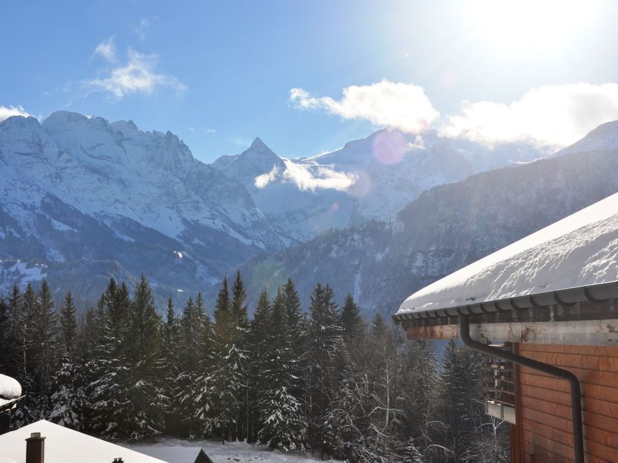 Un paysage de montagne avec des sommets enneigés et un ciel dégagé.