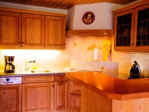 A kitchen with wooden cabinets, a coffee maker, a sink, and a microwave. - HasliRent, Engelhorn, (Hasliberg Reuti), by Interhome (Hasliberg)