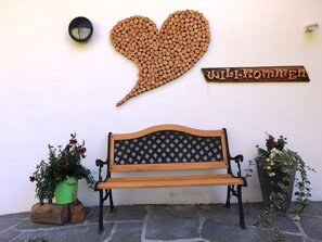A bench with a lattice backrest, a heart-shaped wooden decoration, a wall clock, and a welcome sign. - HasliRent, Holiboimi, (Hasliberg Wasserwendi), by Interhome (Hasliberg)
