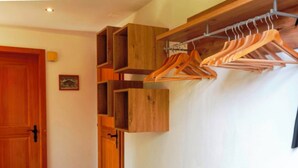 A wooden wardrobe with multiple compartments and a hanging rack with wooden hangers. - HasliRent, Holiboimi, (Hasliberg Wasserwendi), by Interhome (Hasliberg)