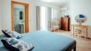 Une chambre à coucher comprenant un lit, une commode, une chaise, un bureau et un miroir.
