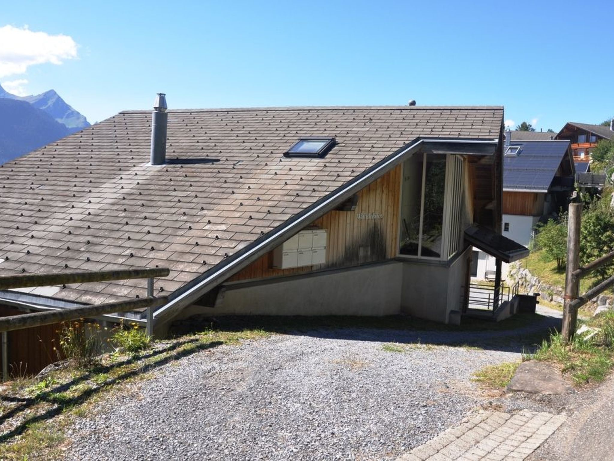 A house with a sloped roof, a chimney, and a small window.