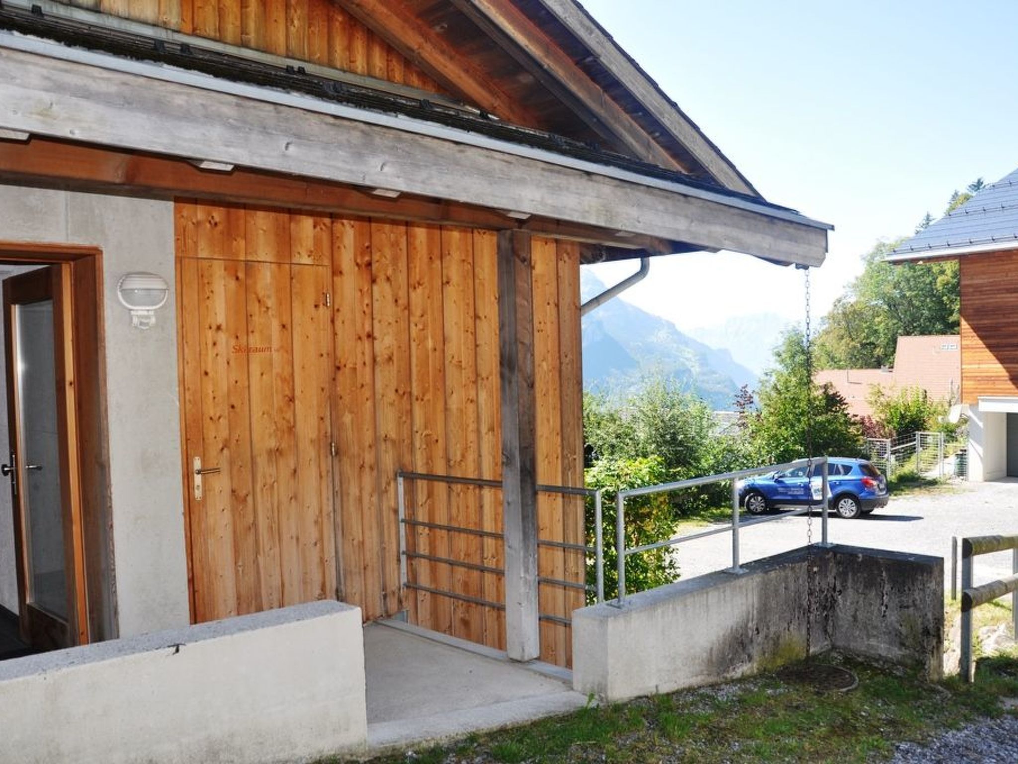 A building with a wooden facade, a metal staircase, and a view of mountains in the background.