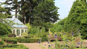 A garden with a gazebo, benches, and a variety of plants. - Simply Hidden Garden Parking By My Getaways (Horsham)