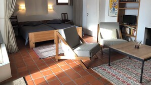 Une pièce confortable avec un lit, une table en bois, une chaise, une bibliothèque et une fenêtre.