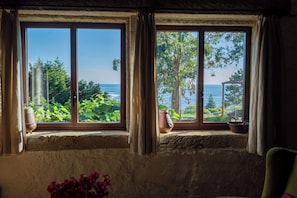 A room with two windows overlooking a garden and the sea. - Stone house with ocean views (A Guarda)