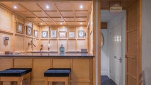 A reception area with a wooden reception desk, framed pictures on the wall, and a clock.