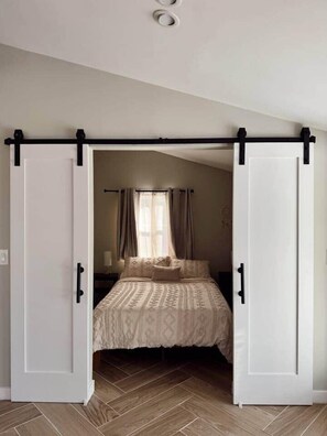 Ein Schlafzimmer mit Bett, Vorhängen und einem Schrank mit Schiebetüren.