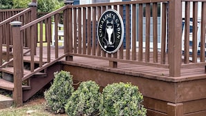 A wooden deck leading to a cabin with a sign reading 'Coraline's Cabin.'