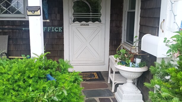 Una casa con puerta blanca, buzón y un letrero que dice '270 Ocean Ave'.