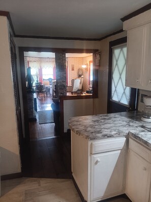 A kitchen with a marble countertop, a white refrigerator, and a wooden dining table with chairs. - Beach 5 min walk Ocean view Spacious 3-bedroom apartment in Hyannis with AC (Barnstable)
