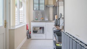 Una cocina compacta con horno, microondas y tostadora integrados.