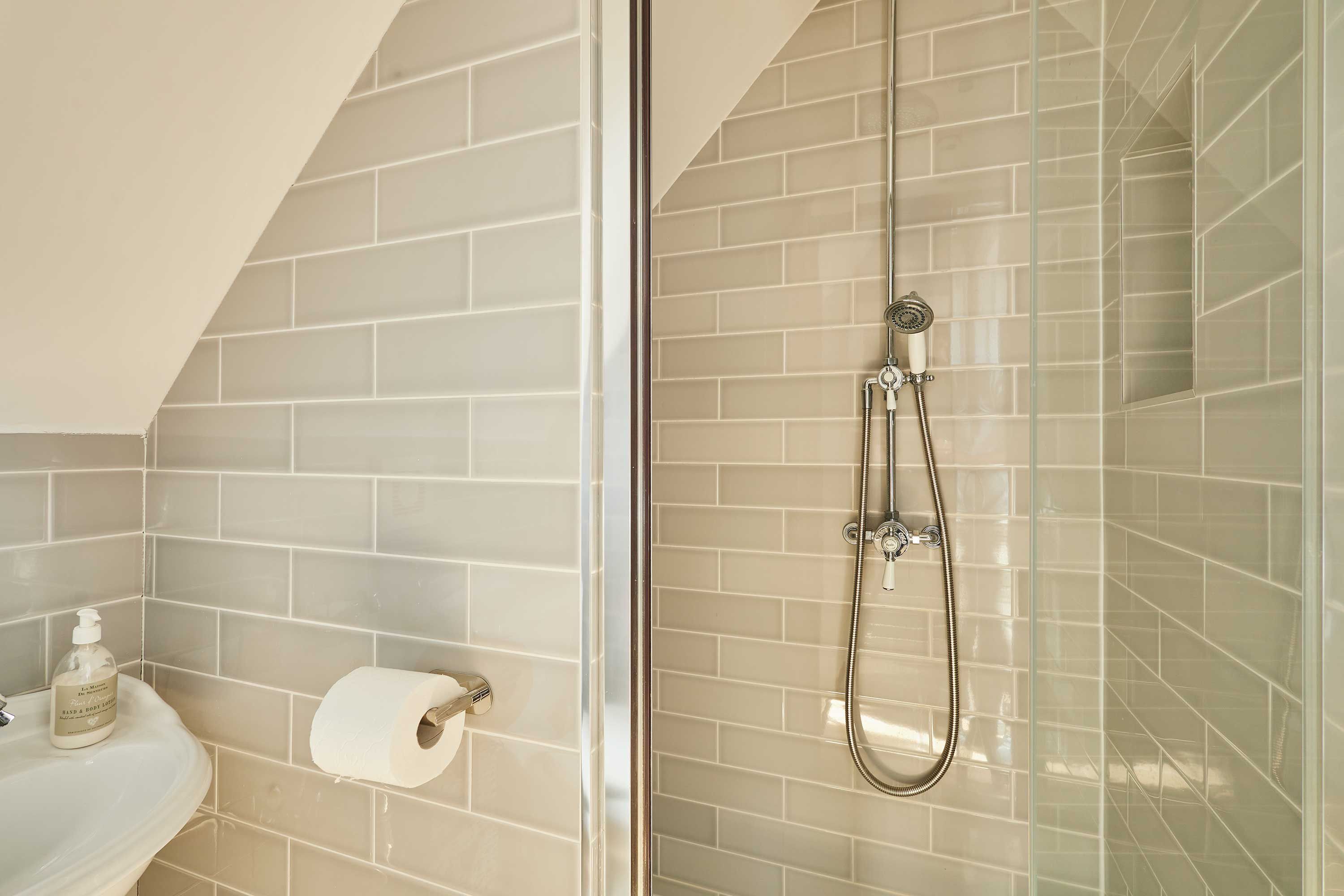 A bathroom with a glass-enclosed shower, a sink, and a toilet.