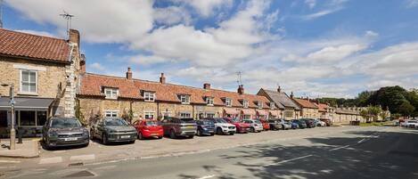 A row of townhouses with parked cars along a street.