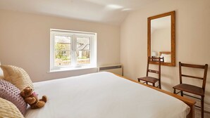Une chambre à coucher avec un lit, une fenêtre, une chaise et un miroir.