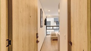 Un pasillo con puertas de madera, una cama y un ventanal con vistas.