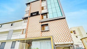 En byggnad med flera våningar och modern design, med en framträdande skylt som visar texten ”TOWNHOUSE”.
