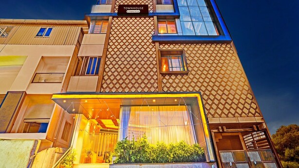 En byggnad med flera våningar, och en skylt som visar texten ”TOWNHOUSE & Company Services”.