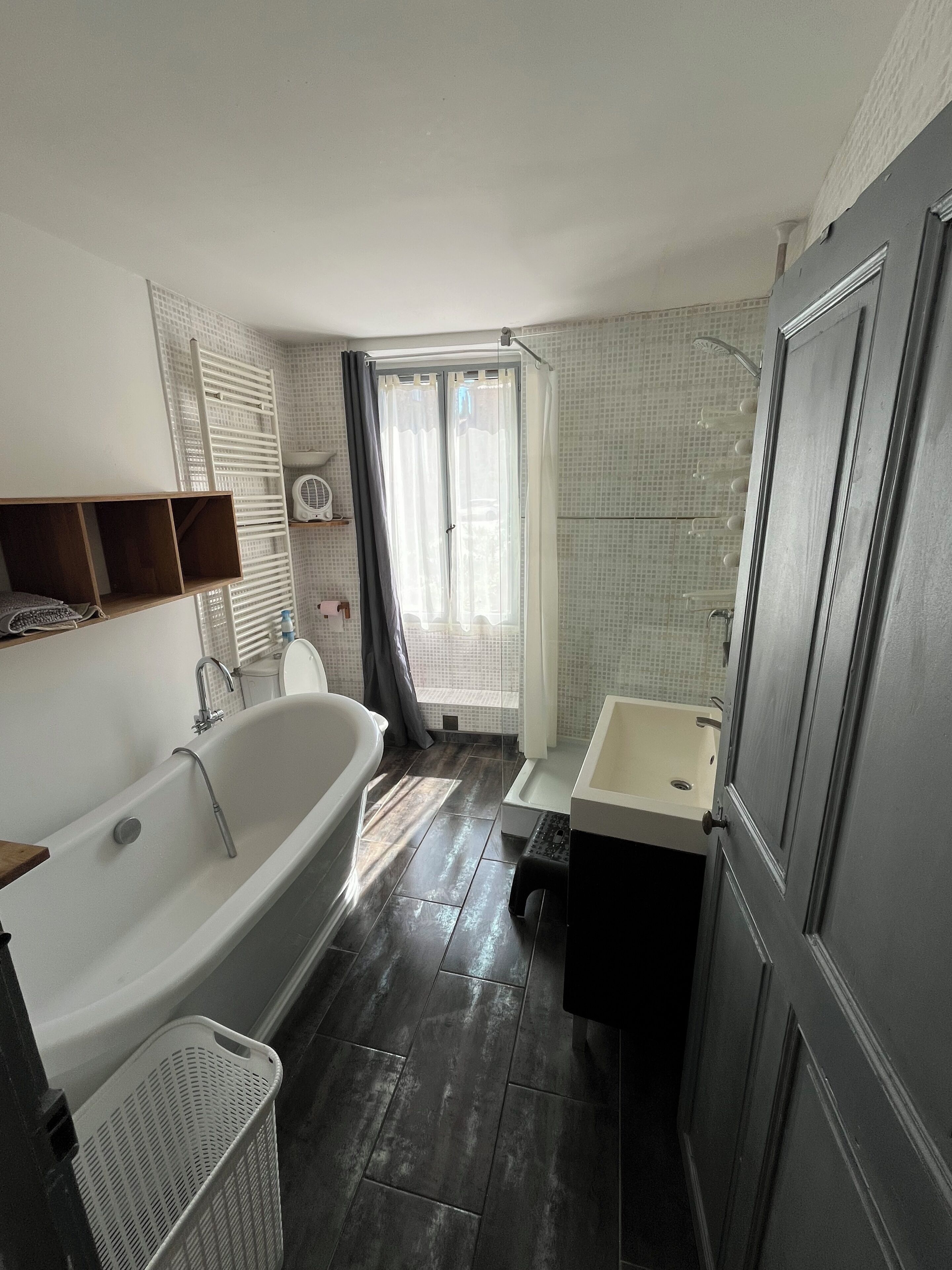 Une salle de bain avec une baignoire, un lavabo et un espace douche.