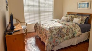 Una camera da letto con un letto, una scrivania e una finestra con persiane.