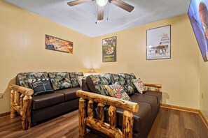 A living room with a brown sofa set, wooden coffee table, and a ceiling fan. - Mountain Views, Hot Tub, Pool Access (Gatlinburg)