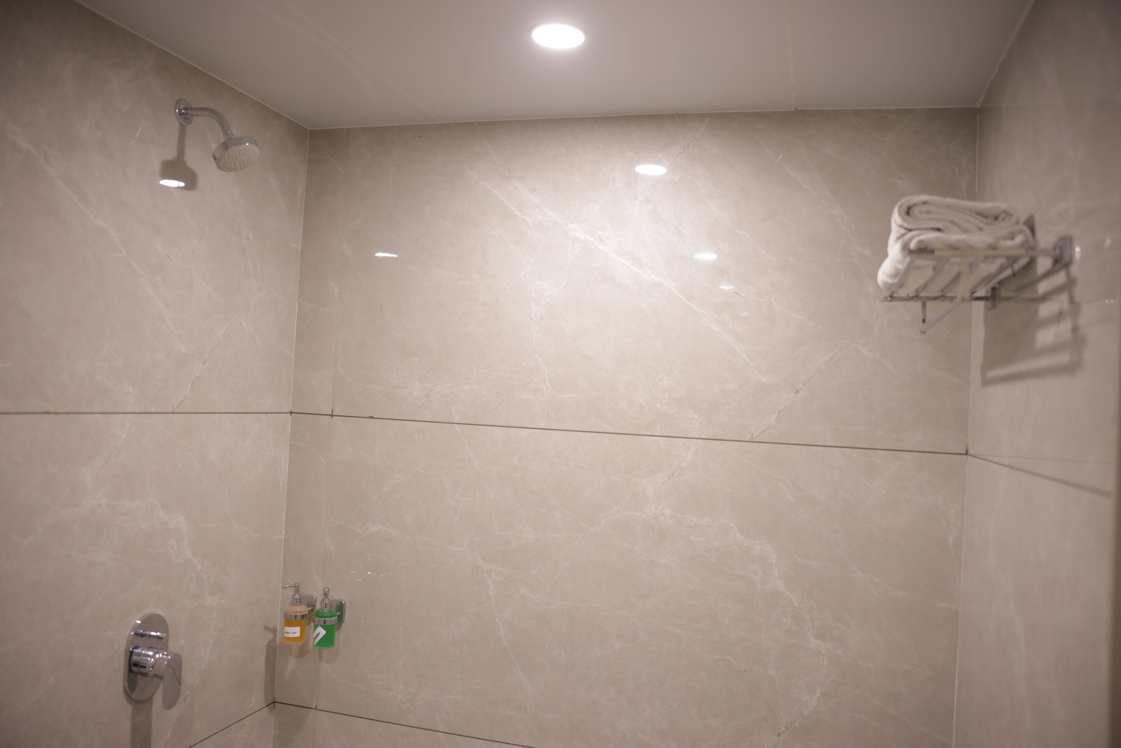 A bathroom with a shower, a towel rack, and a mirror.