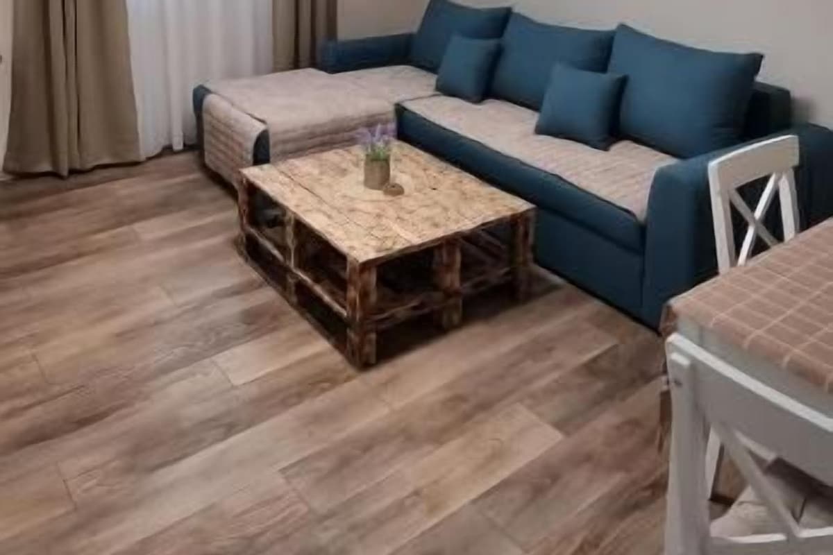Een moderne woonkamer met een hoekbank, een salontafel en een eettafel.